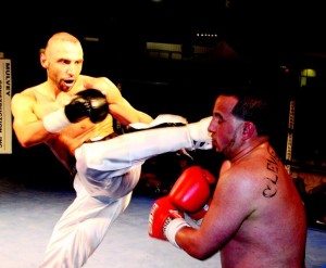 Lockport’s Amer Abdallah delivers a solid leg kick to the head of Scott Muller of Shreveport, La., in a fight last July at the Kenan Center Arena. Abdallah will fight heavyweight Jerald “The Gettoblaster” Johnson of Milwaukee this Saturday night in a professional kickboxing main event at the Kenan.